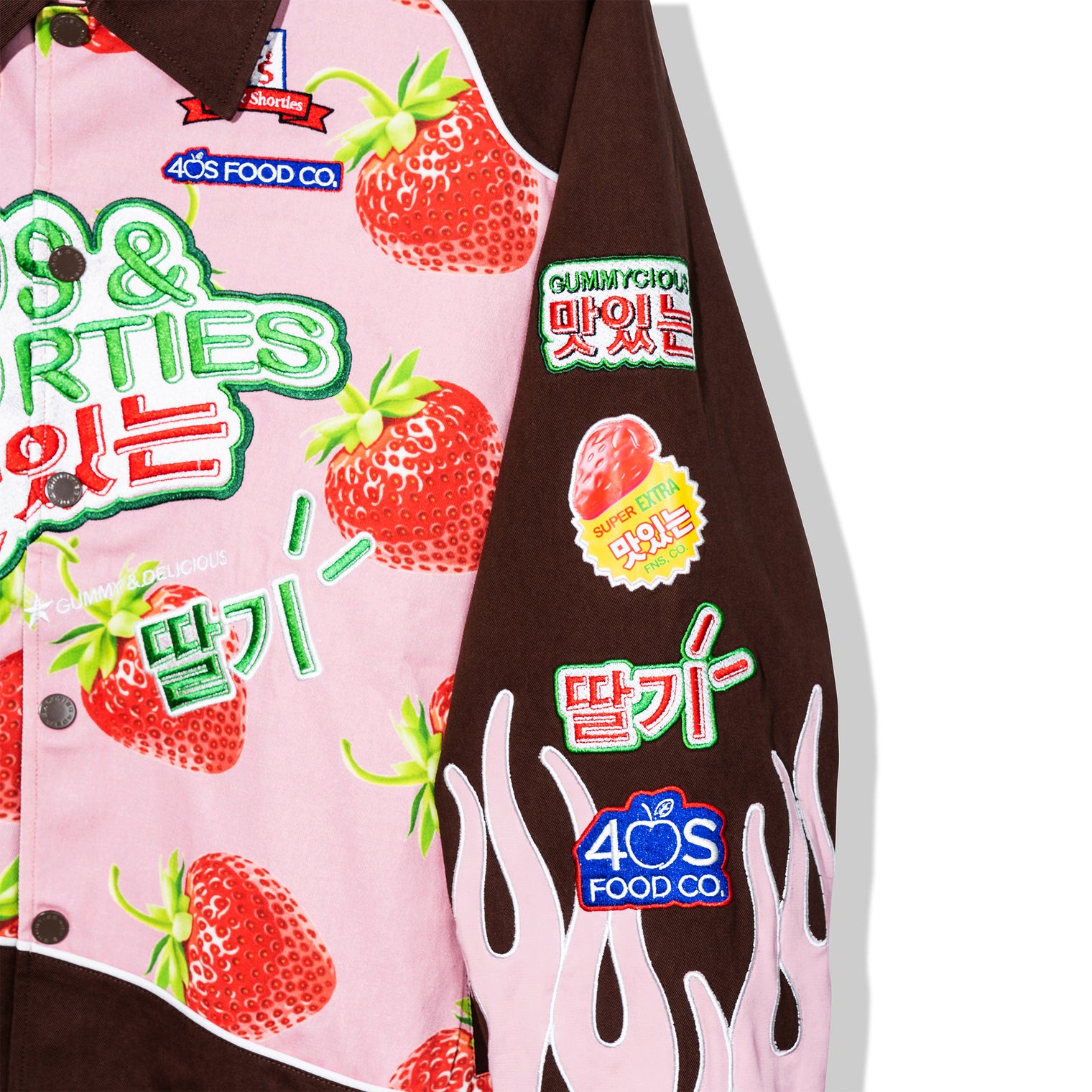 Left sleeve of the Gummy Race Jacket with embroidered strawberry graphics and flame accents
