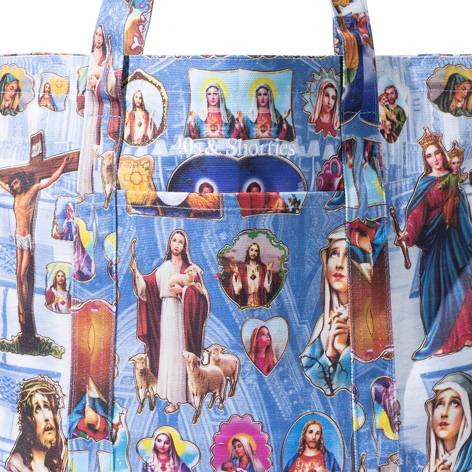 Close-up of the Holy Spirit Tote Bag front pocket, showing detailed religious artwork and embroidered 40s & Shorties logo.