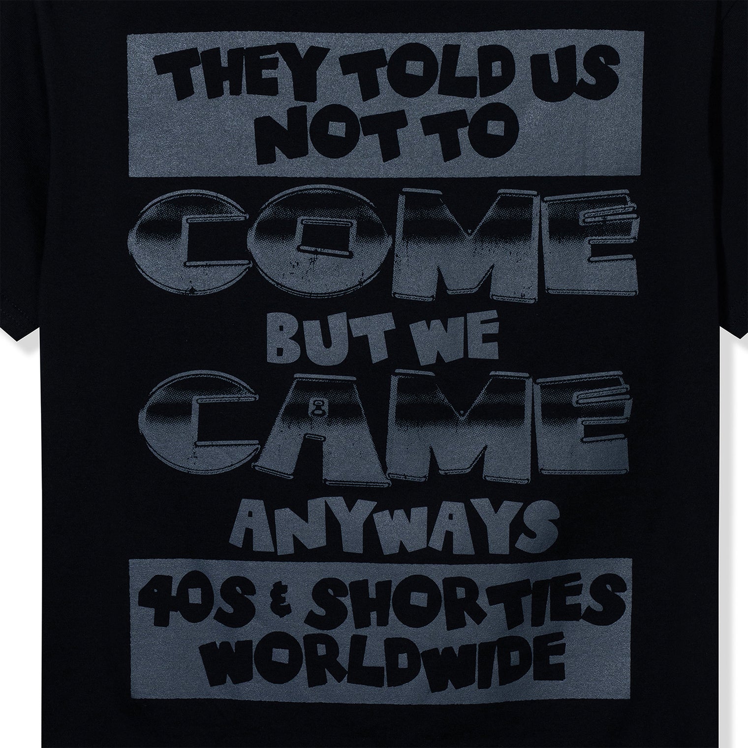 Back graphic close-up with bold “They Told Us Not To Come…” slogan in grayscale print.