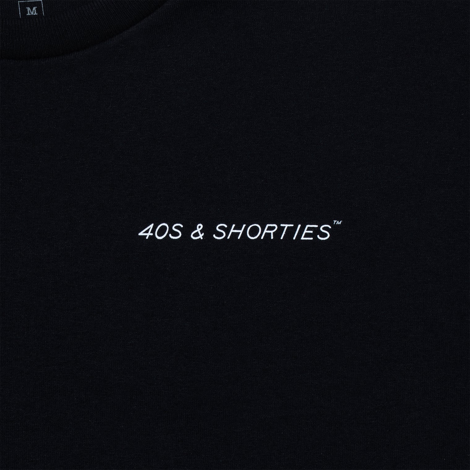 Close-up of the front chest logo reading “40s & Shorties” on black cotton.