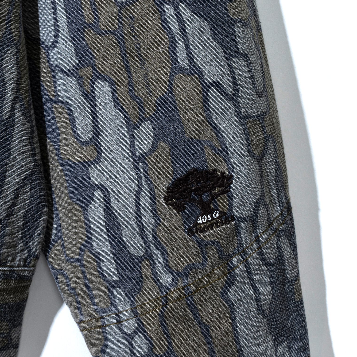 Embroidered tree logo on sleeve of Treeline Jacket – Camo