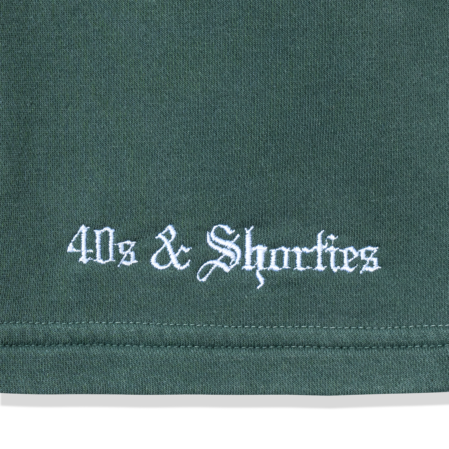 Close-up of white embroidered 40s & Shorties logo on Alpine fleece fabric