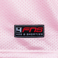 Detailed view of woven FNS logo label at the hem of the Fubar Jersey in Pink.