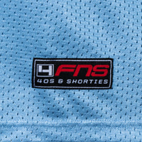 Detailed view of woven FNS logo label at the hem of the Fubar Jersey in Blue.