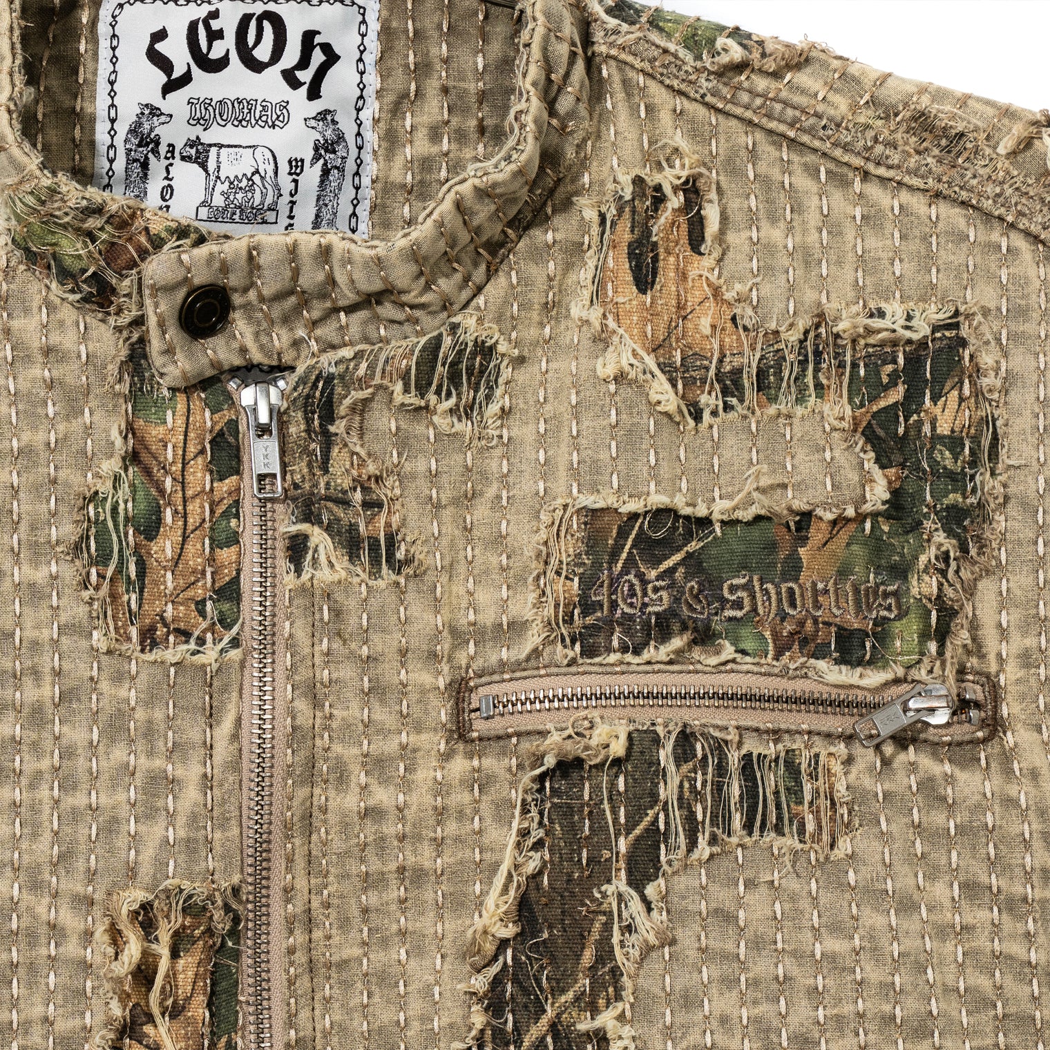 Close-up of Boro Jacket chest showing distressed boro stitching, camo under-layer, and 40s & Shorties embroidery