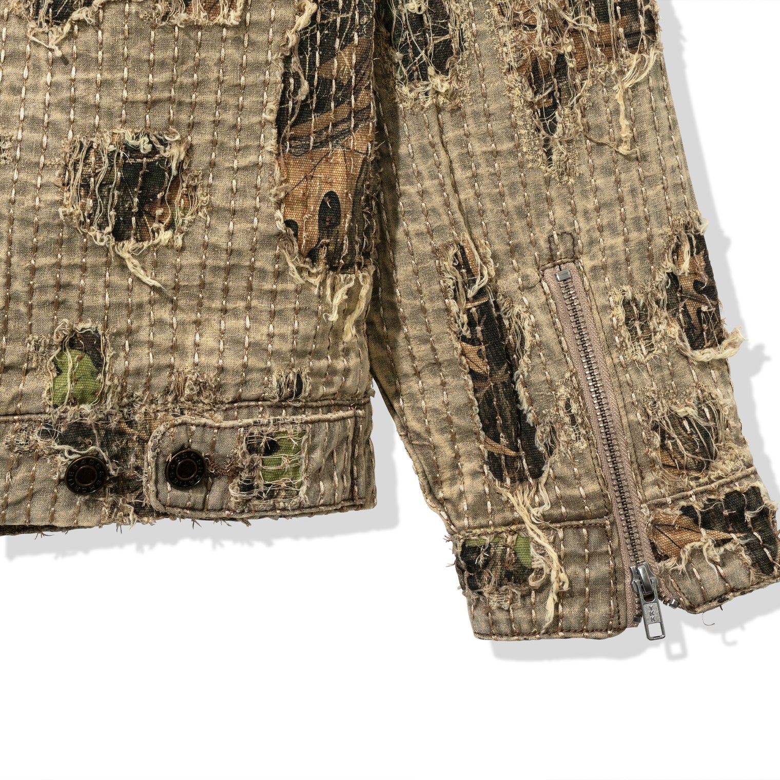 Detail shot of Boro Jacket sleeve hem with distressing, camo under-layer, and YKK zipper