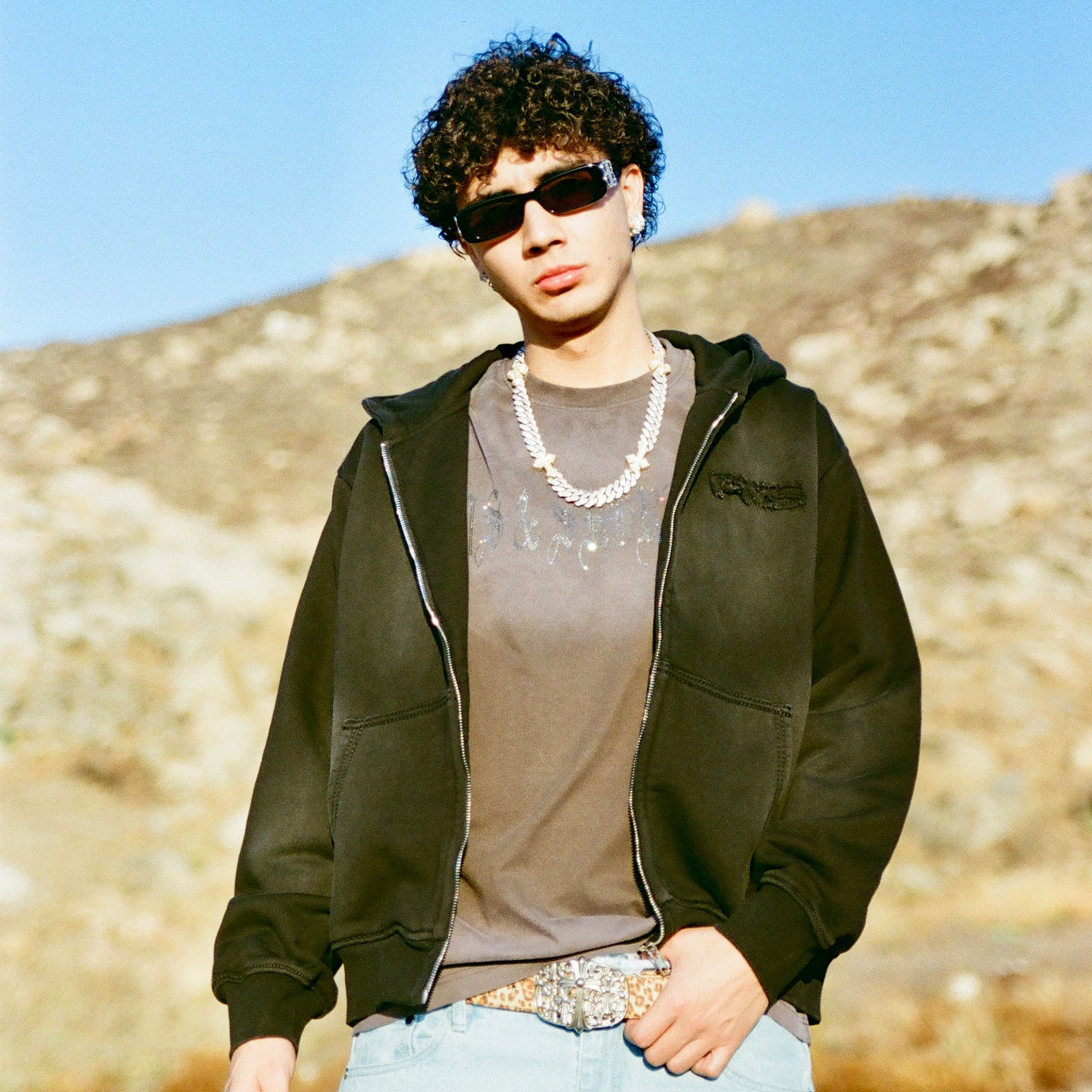 Model in 40s & Shorties Faded Logo Zip Hoodie black, standing in desert landscape.