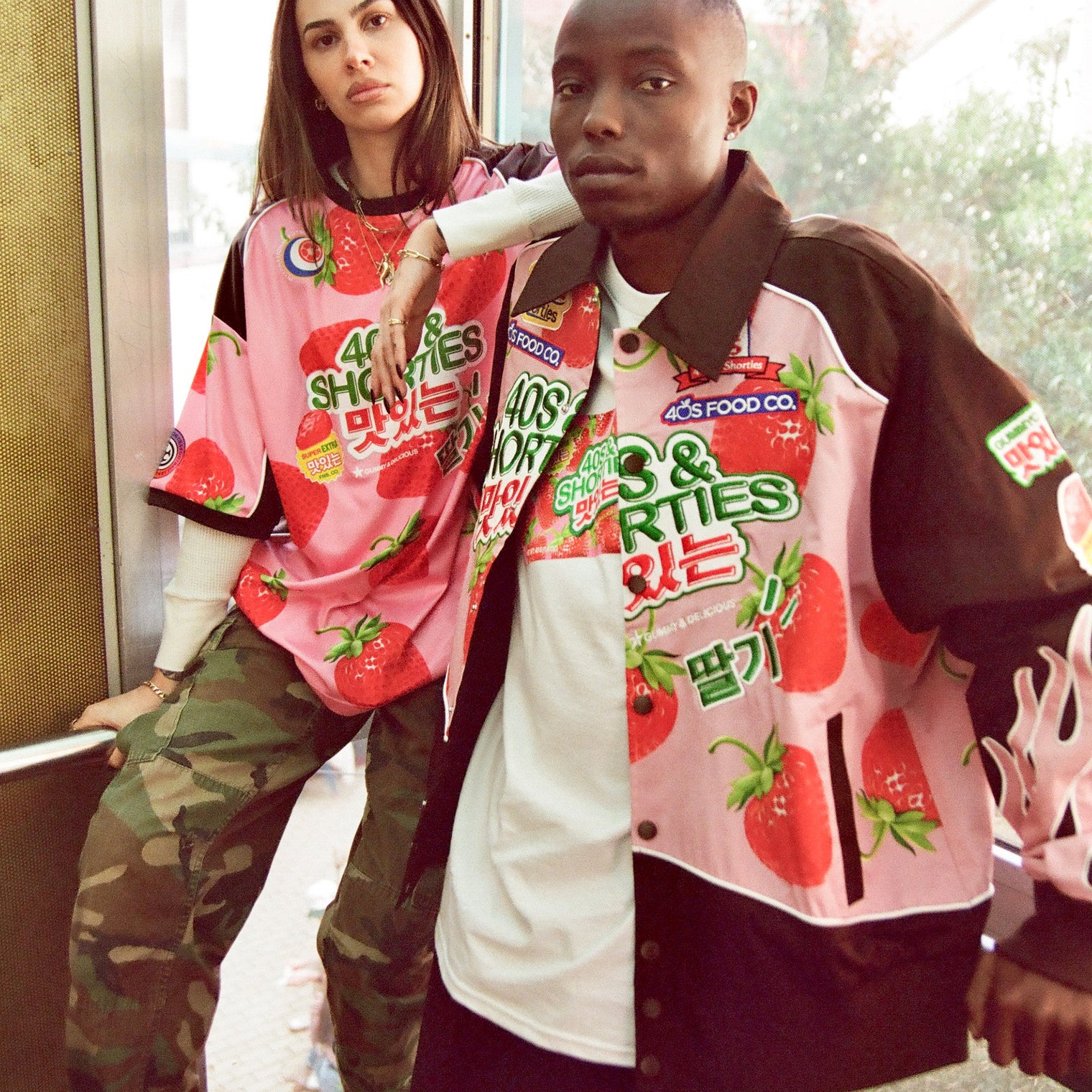 Two models wearing matching 40s & Shorties strawberry-themed Gummy pieces, including the Race Jacket