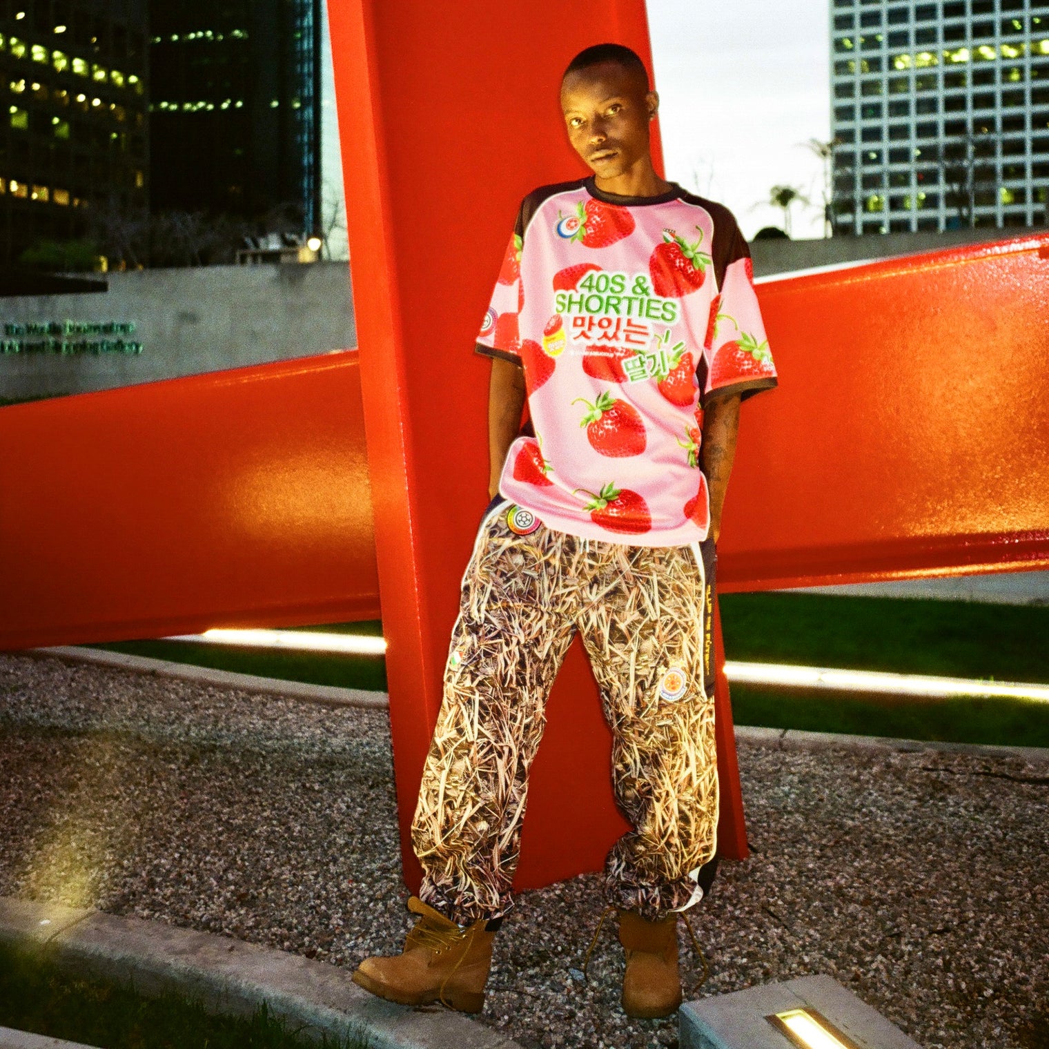 Night-time urban shot of model wearing the jersey with patterned pants and boots