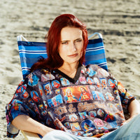 Female model wearing the jersey, lounging on a striped chair at the beach