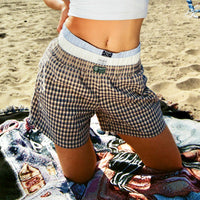 Woman kneeling on the beach wearing Lazy Sunday Shorts