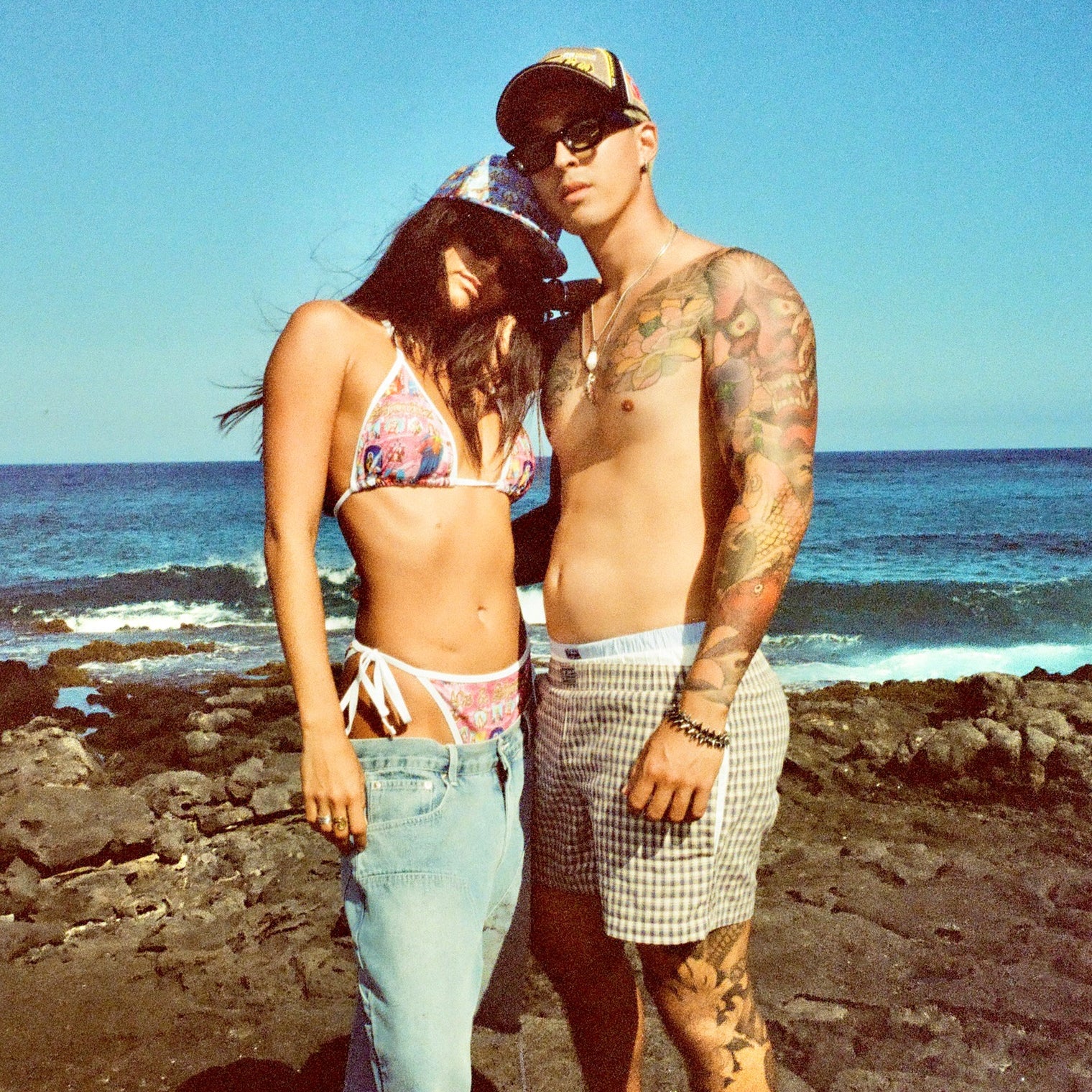 Lazy Sunday Shorts worn by man with bikini-wearing partner on the coast