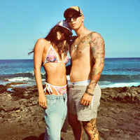 Lazy Sunday Shorts worn by man with bikini-wearing partner on the coast