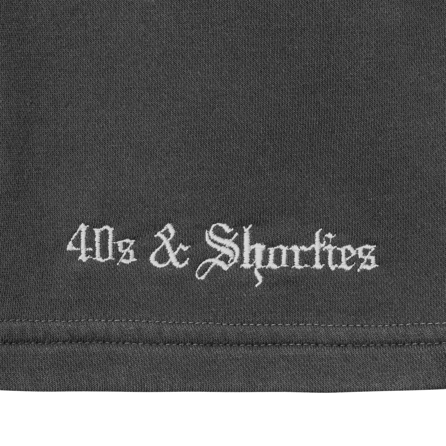 Close-up of white embroidered 40s & Shorties logo on Charcoal fleece fabric