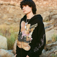 Model wearing 40s & Shorties Psycho Bunny Hoodie in black with Kevin Mejia artwork on chest and rhinestone script on sleeve.