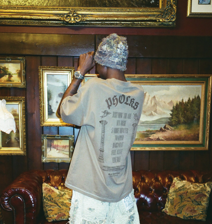 Model wearing PHOLKS Tee in washed brown showing full back graphic design