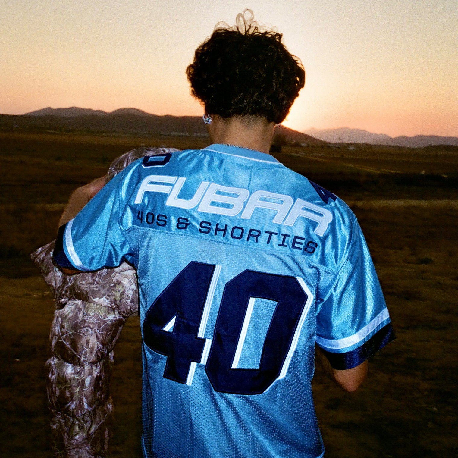 Model showing back view of Fubar Jersey in Blue with “FUBAR” and “40” appliqué visible.