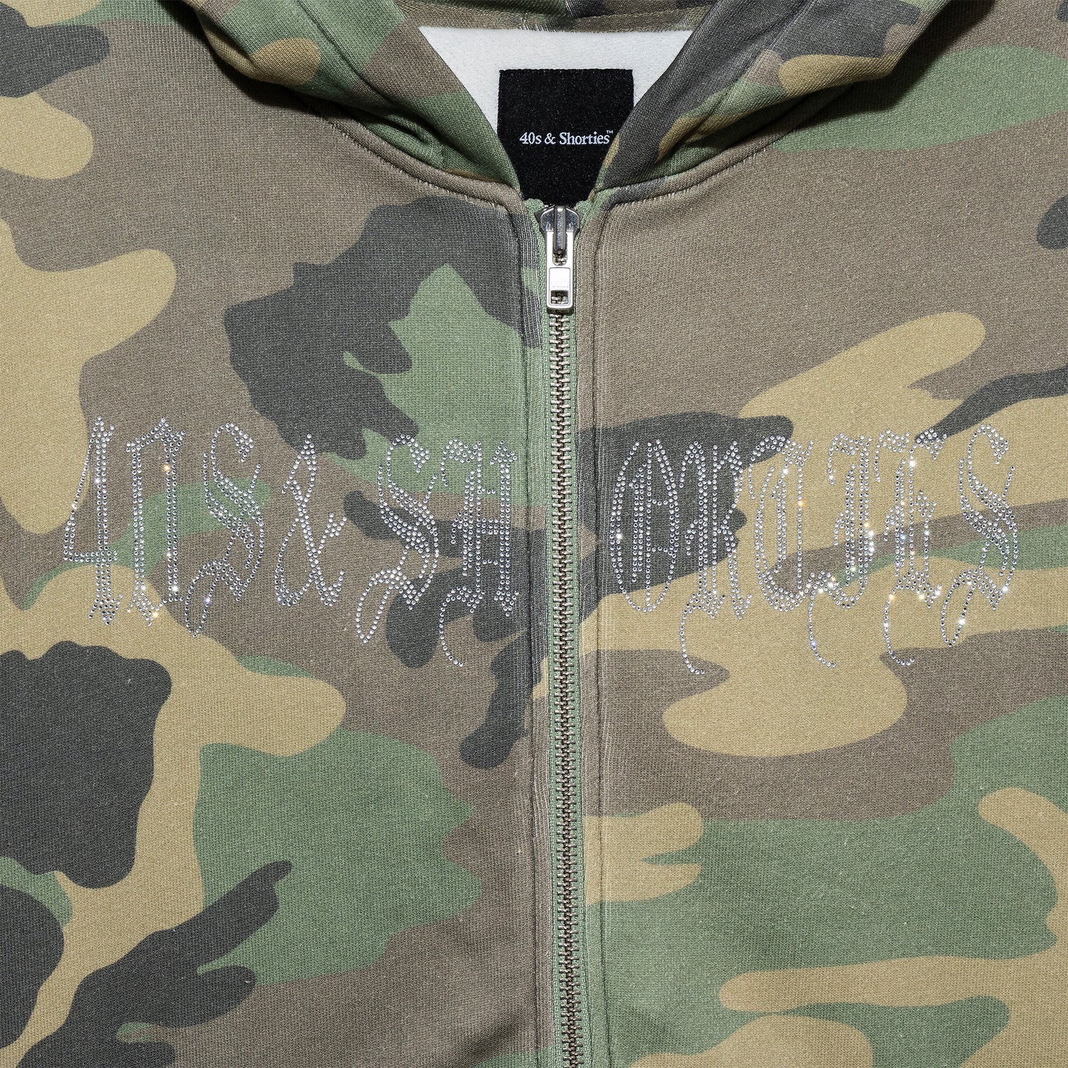 Close-up of Angel Wings Hoodie – rhinestone 40s & Shorties logo on camo fleece