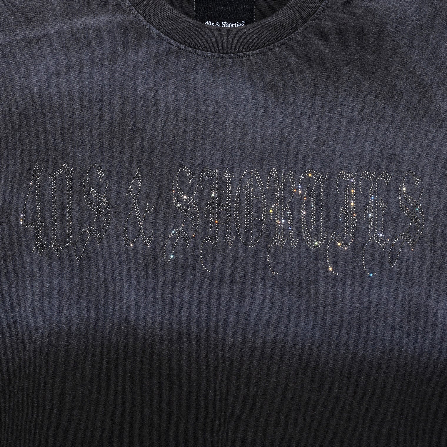 Close-up of rhinestone 40s & Shorties logo on chest of Angel Wings Tee in Charcoal
