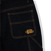 Close-up of back pocket embroidery on Standard Carpenter Shorts featuring gold stitched globe logo