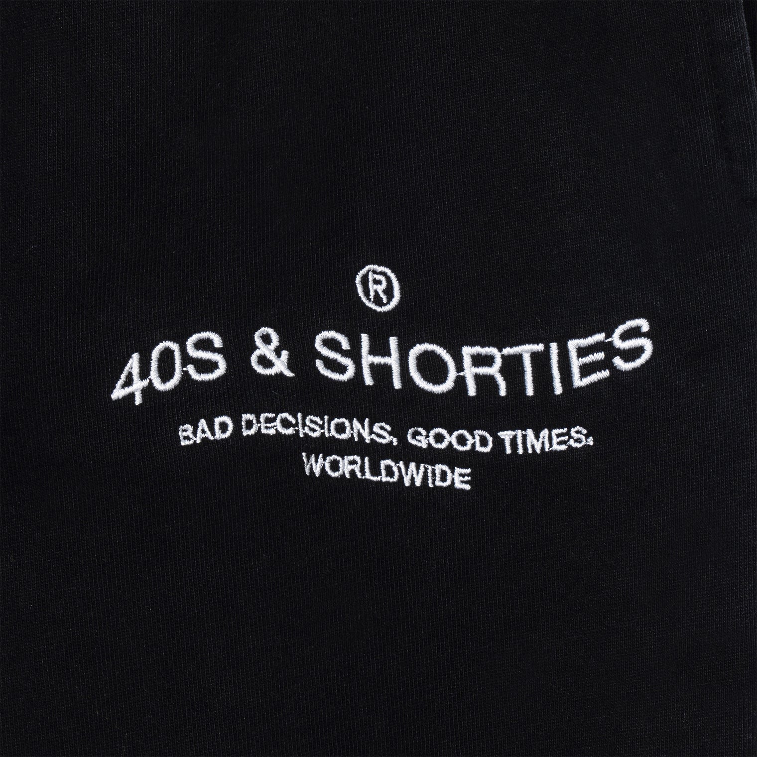 Close-up of 40s & Shorties “Bad Decisions, Good Times, Worldwide” printed logo on sweatpants
