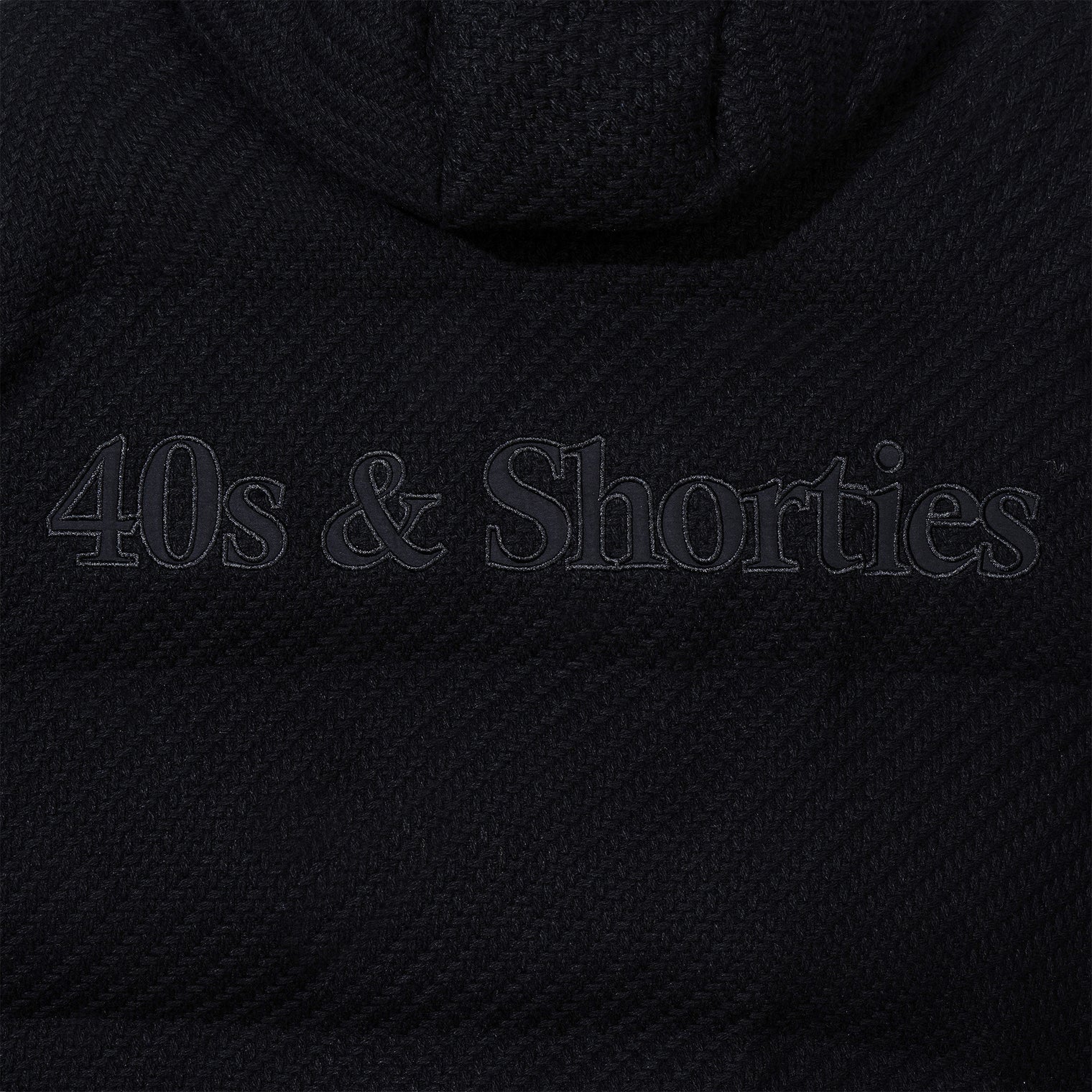 Close-up of tonal logo applique on the back of the jacket