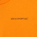 Close-up of front chest print on the Grid Tee Tangerine featuring "40s & Shorties" text in black.
