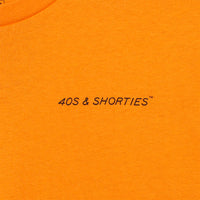 Close-up of front chest print on the Grid Tee Tangerine featuring "40s & Shorties" text in black.
