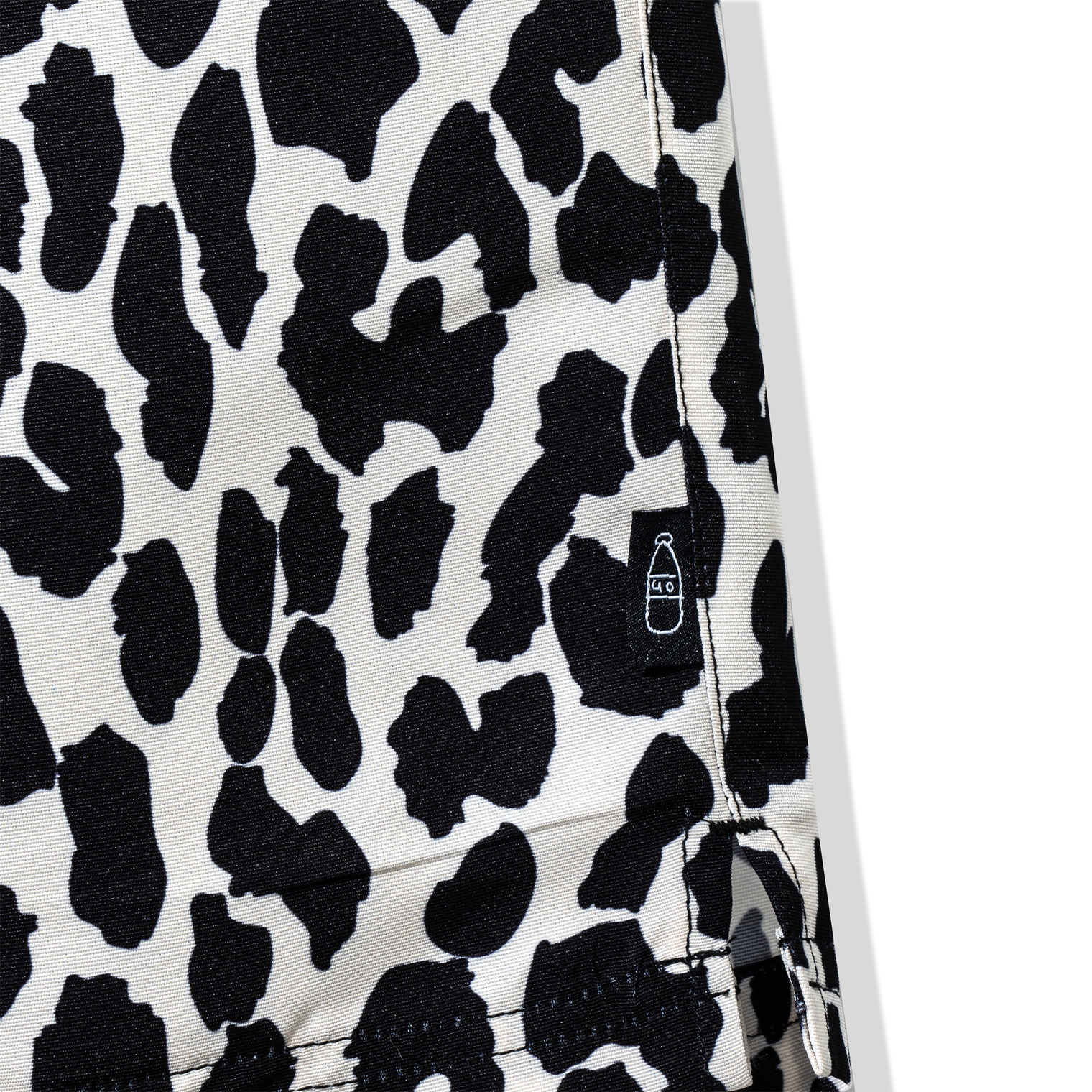 Close-up of 40s & Shorties bottle logo tag on leopard print shorts
