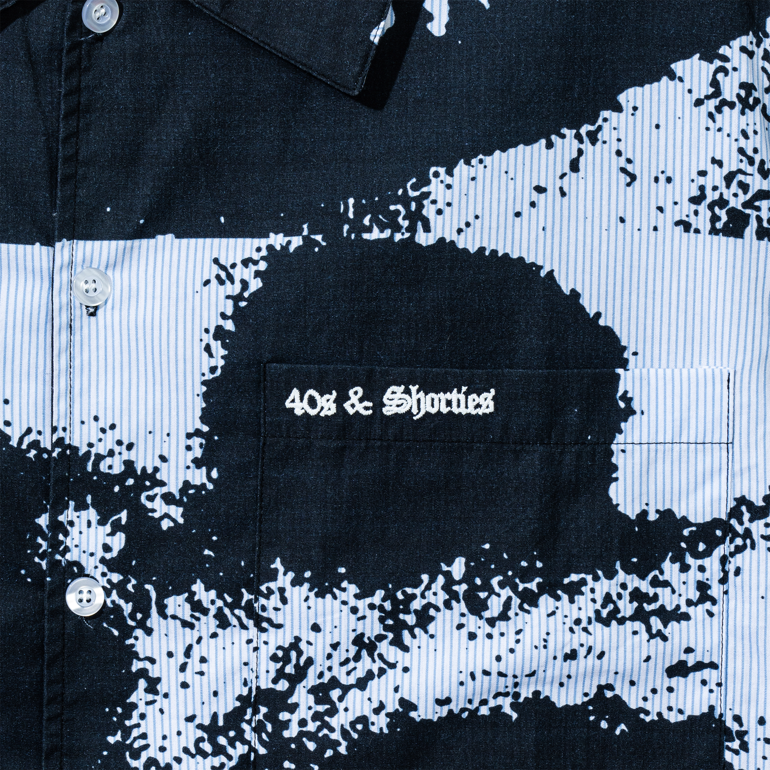 Close-up of chest pocket on the Lips Shirt in Black showing embroidered "40s & Shorties" logo on printed lips graphic.
