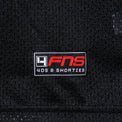 Detailed view of woven FNS logo label at the hem of the Fubar Jersey in Black.
