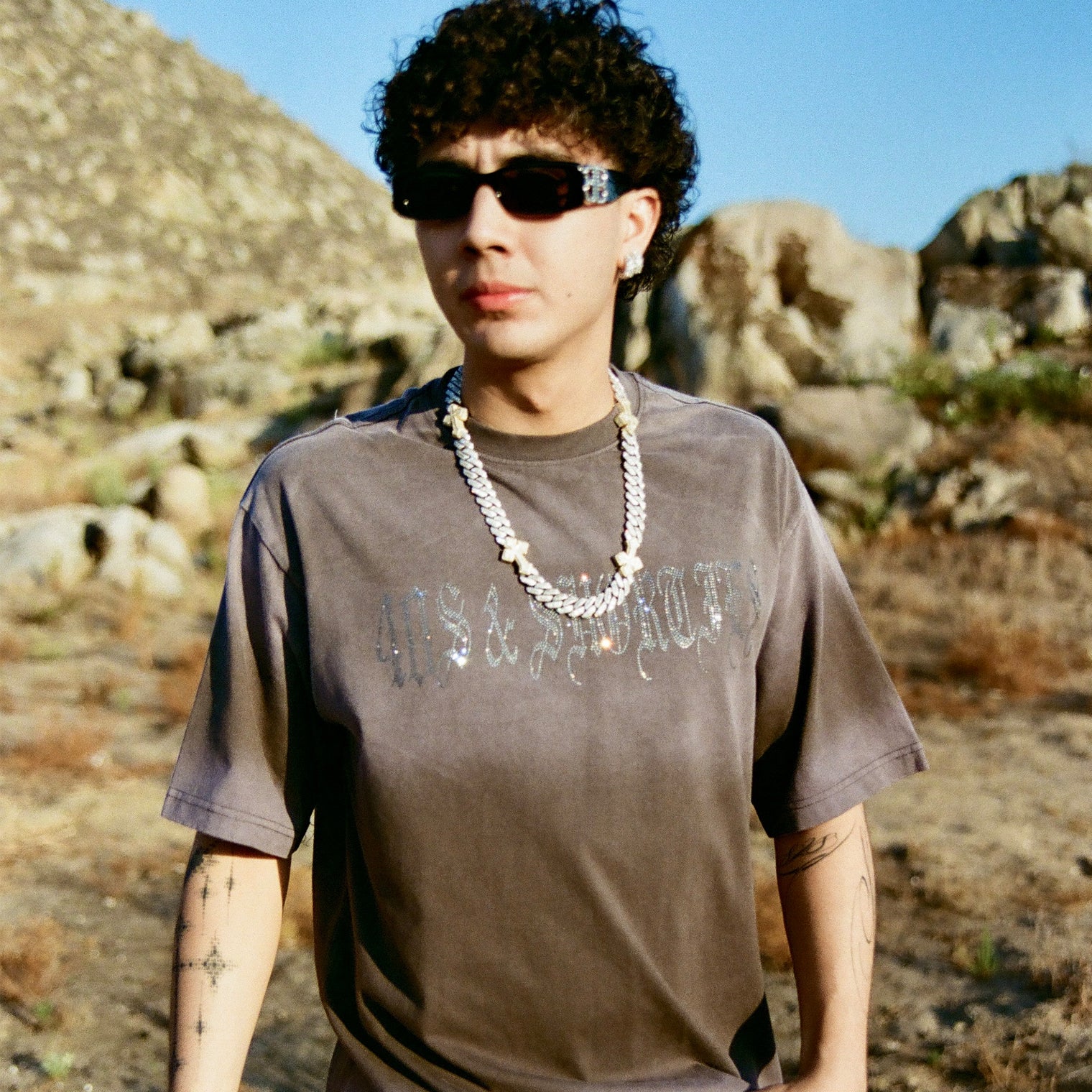 Model wearing 40s & Shorties Angel Wings Tee in black with rhinestone script logo across chest.
