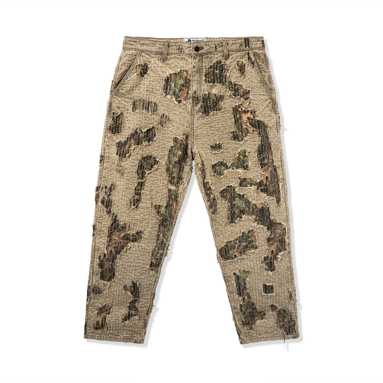 Front view of Boro Pants featuring canvas shell, distressed texture, and printed tree camo under-layer
