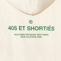 Detailed view of printed “40S ET SHORTIÉS” graphic with French text on back of cream hoodie – 40s & Shorties.
