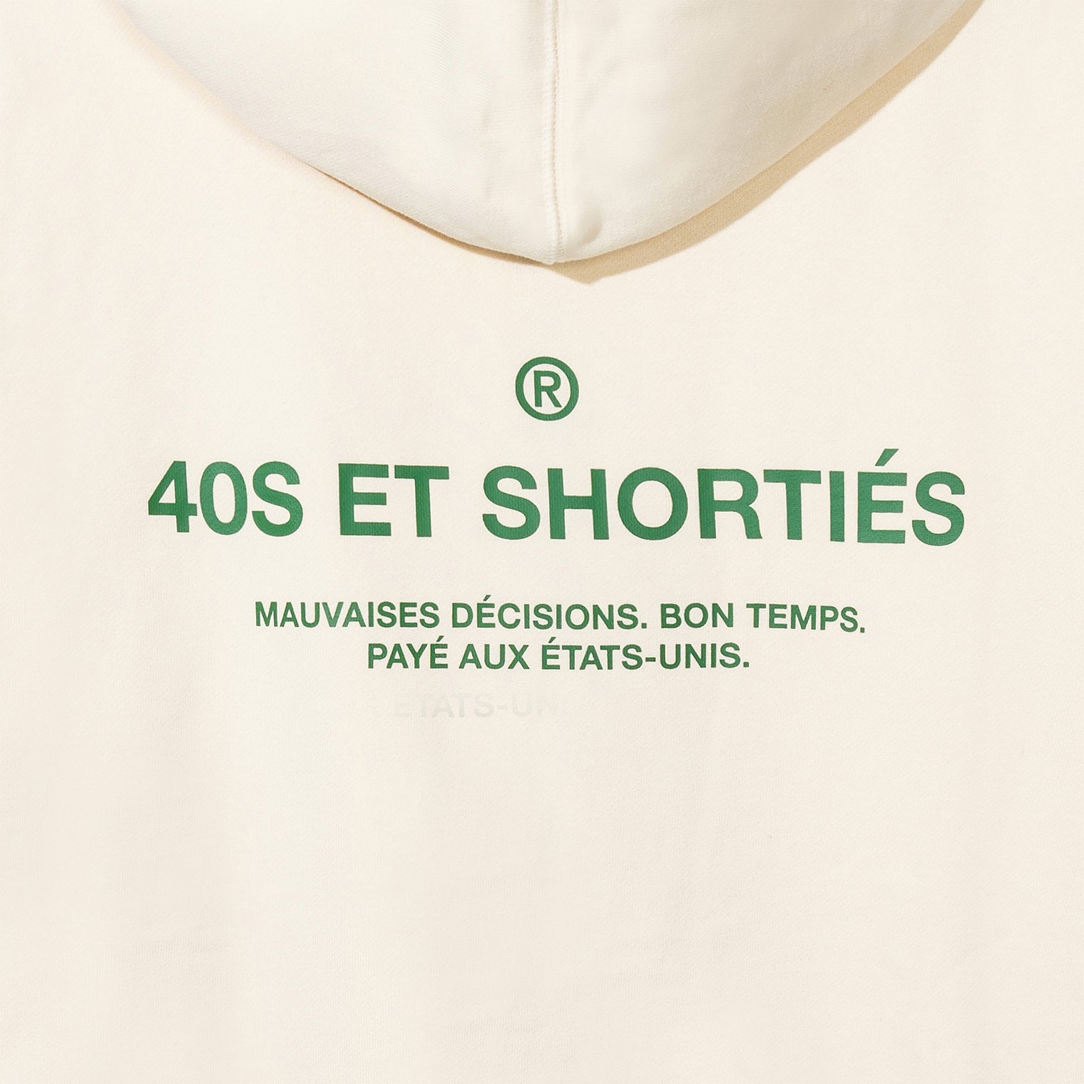 Detailed view of printed “40S ET SHORTIÉS” graphic with French text on back of cream hoodie – 40s & Shorties.
