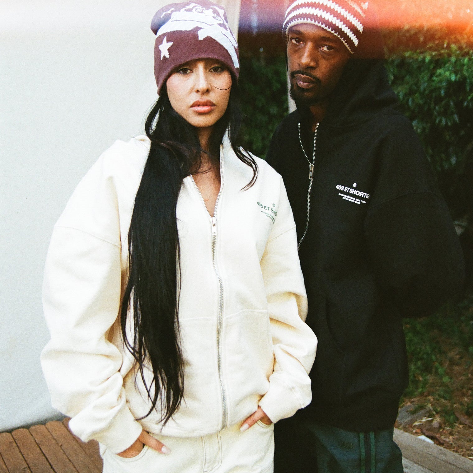 Models wearing French General Zip Hoodies in cream and black, showcasing front text graphics – 40s & Shorties.
