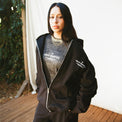 Female model wearing French General Zip Hoodie in black, layered over matching graphic tee – 40s & Shorties.