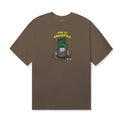Front view of the Garbage Tee in Prairie Dust by 40s & Shorties featuring a printed cartoon trash can graphic with a green character and “40s & Shorties” text above.
