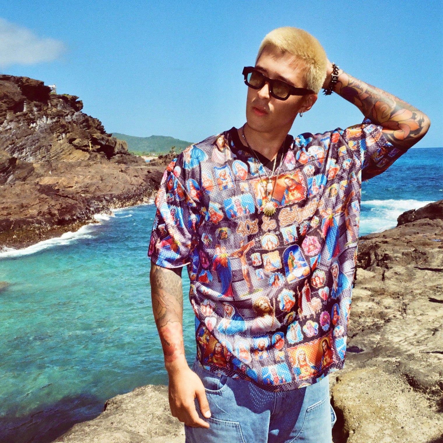Male model standing on rocky coastline, hand on head, wearing the Holy Spirit Football Jersey
