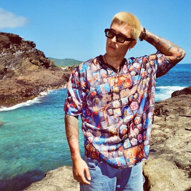 Male model standing on rocky coastline, hand on head, wearing the Holy Spirit Football Jersey
