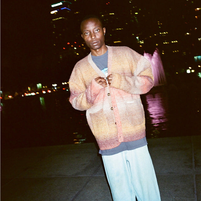 Model wearing the Lithium Cardigan by a fountain at night
