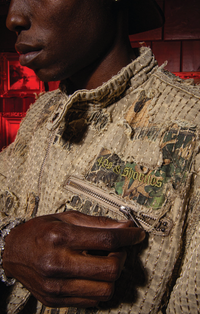 Model wearing Boro Jacket, unzipping chest pocket with 40s & Shorties embroidery detail
