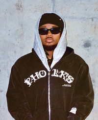 Model standing in Triple Zip Hoodie with layered front panels and zippers
