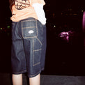 Model wearing Standard Carpenter Shorts at night, highlighting pocket and contrast stitching details