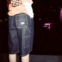 Model wearing Standard Carpenter Shorts at night, highlighting pocket and contrast stitching details
