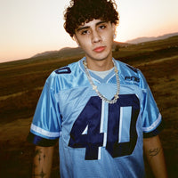 Male model wearing the Fubar Jersey in Blue, showing front appliqué.
